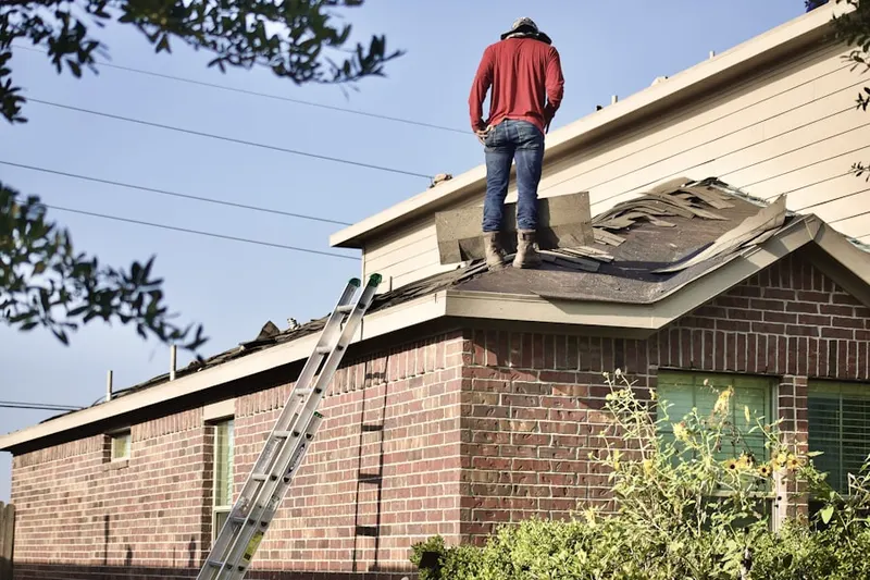 Professional roofer working on a residential roof in Randall